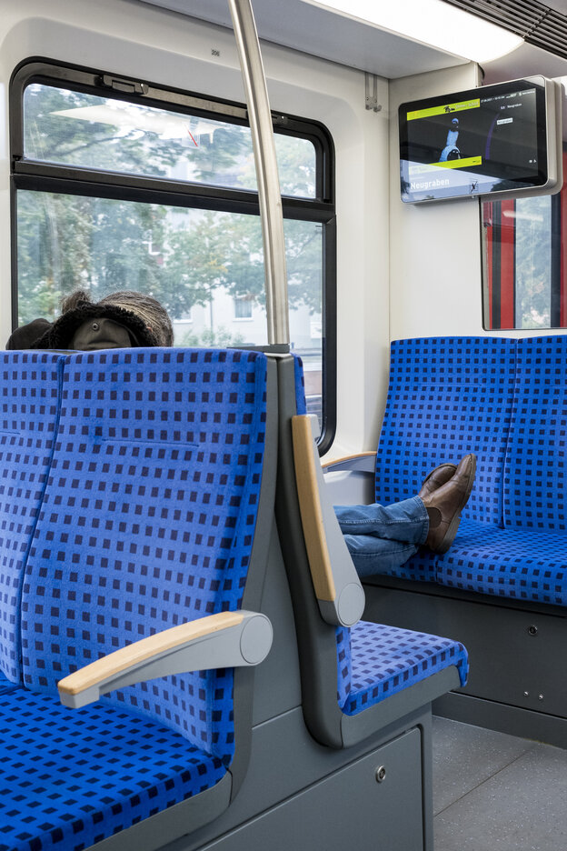Ein Zugabteil im Nahverkehr mit blauen Sitzen