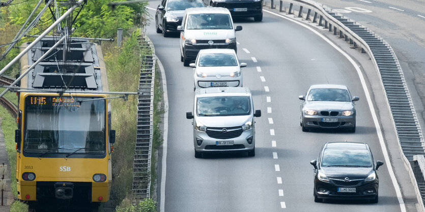 Eine U-Bahn in Stuttgart fährt neben zwei Autobahnspuren entlang