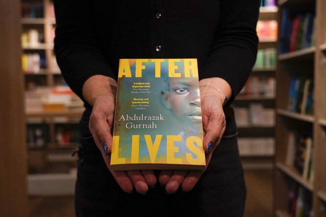 eine Frau hält das Buch "After Lives" in die Kamera