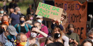 mehrere Menschen auf einer Demo, ein Kind hält ein Schild hoch