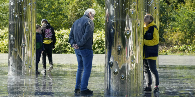 Menschen stehen vor einer Kunstinstallation, die an das Massaker von Babyn Jar erinnert.