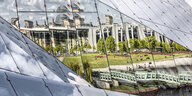Reichstag mit Kuppel und Deutschlandfahne hinter dem Paul-Loebe-Haus, Spiegelung in Glasfassade