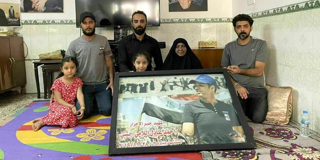 Eine sechsköpfige Familie posiert für ein Foto mit einem großen Bild