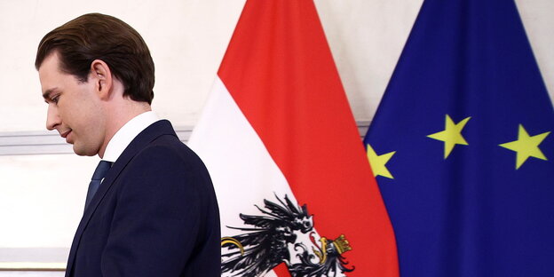 Ein Mann, naben die österrichische und Europaflagge