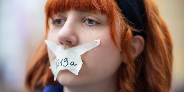 Eine Demonstrantin hat sich den Mund mit Klebestreifen zugeklebt