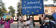 Vor dem Sitz des polnischen Verfassungsgerichts protestieren mehrere Menschen mit Schildern und Transparenten