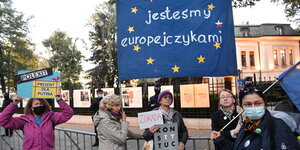Vor dem Sitz des polnischen Verfassungsgerichts protestieren mehrere Menschen mit Schildern und Transparenten