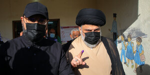 Der schiitische Geistliche Muktada al-Sadr (r) zeigt seinen mit Tinte verschmierten Finger, nachdem er in einem Wahllokal während der Parlamentswahlen seine Stimme abgegeben hat.
