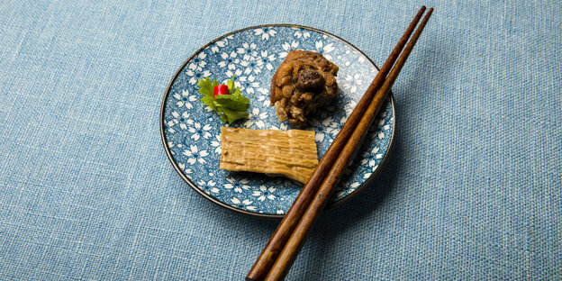 Ein Teller gefüllt mit getrockneten Bambusspprossen und gegrilltem Fleisch