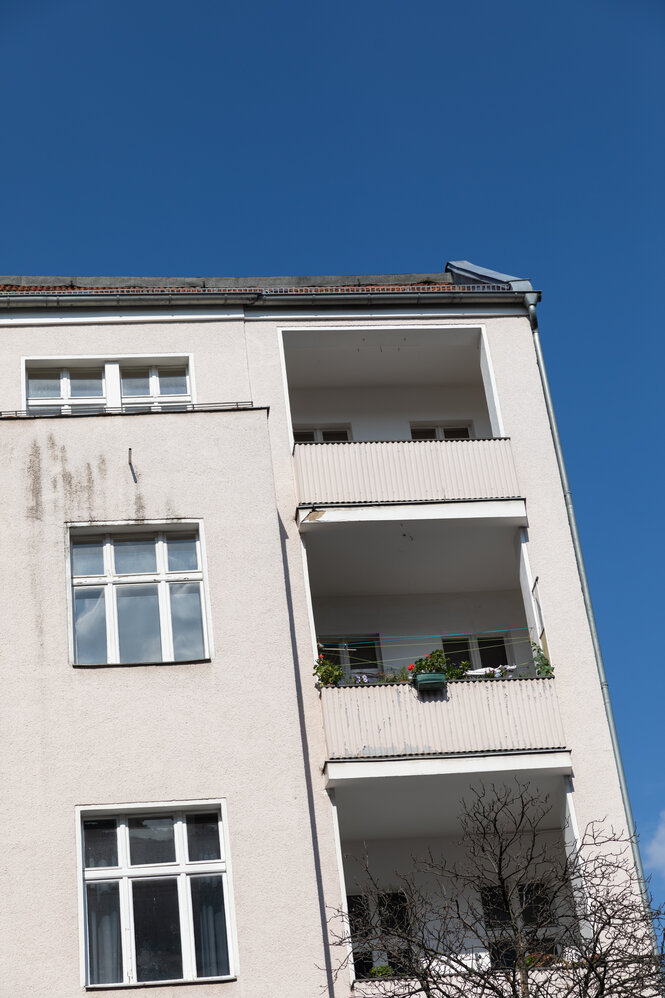 Aussenansicht enes Hauses mit Balkonen vor blauem Himmel