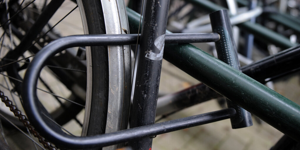 Ein Fahrrad ist mit einem Schloss an einen Fahrradständer angekettet