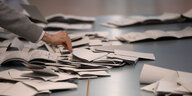 Wahlhelfer und Wahlhelferinnen zählen in einem Wahllokal Stimmzettel für die Bundestagswahl. Am 26. September findet die Bundestagswahl 2021 statt