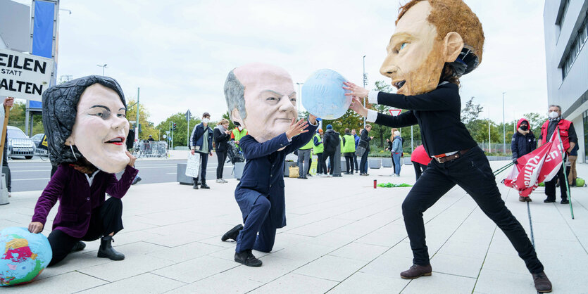 Personen mit Masken bei einer Protestaktion.