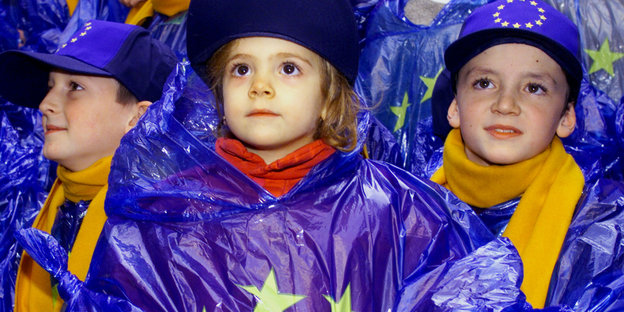 Kinder tragen Jacken und Mützen mit der Euroflagge