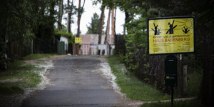 Ein mit Kiefern gesäumter Weg führt zu Häsuern - am Eingang steht gelbes Schild: Haus Babenberg