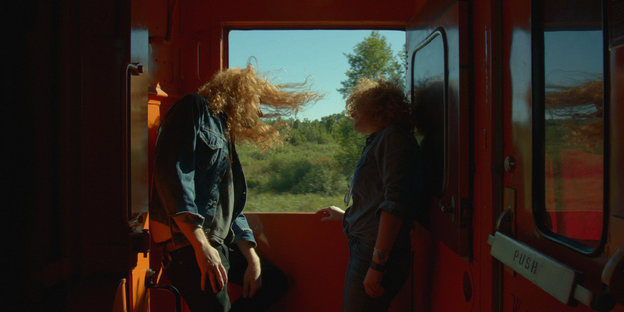 Männer mit wehenden Haaren im Zug