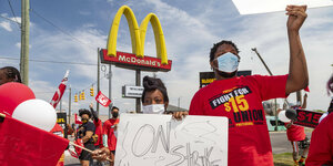 Angestellt von McDonalds streiken vor einem Firmenschild