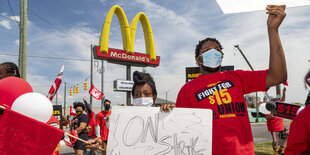 Angestellt von McDonalds streiken vor einem Firmenschild