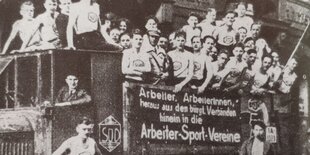 Arbeitersportler des Vereins "Fichte" werben auf einem LKW für ihren Verein