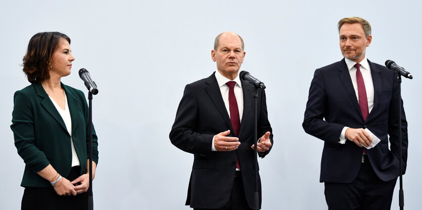 Annalena Baerbock, Olaf Scholz und Christian Linder stehen zusammen vor Mikrofonen