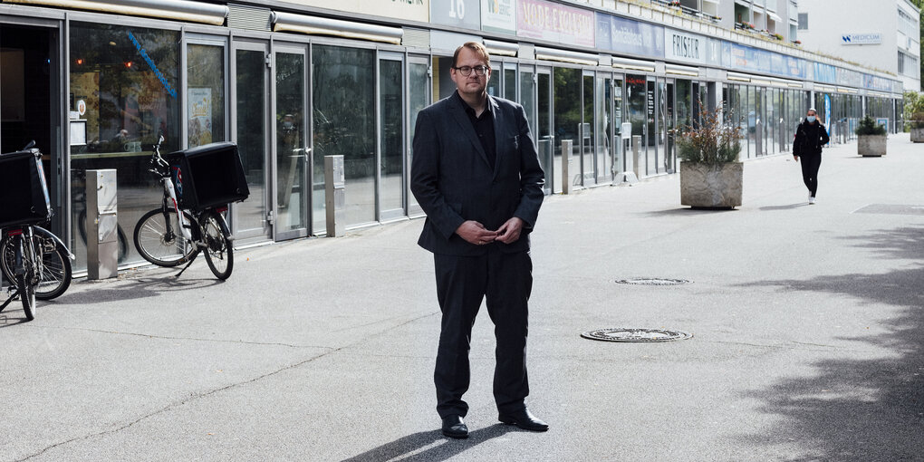 Sören Pellmann steht in einer Ladenzeile in Leipzig Grünau