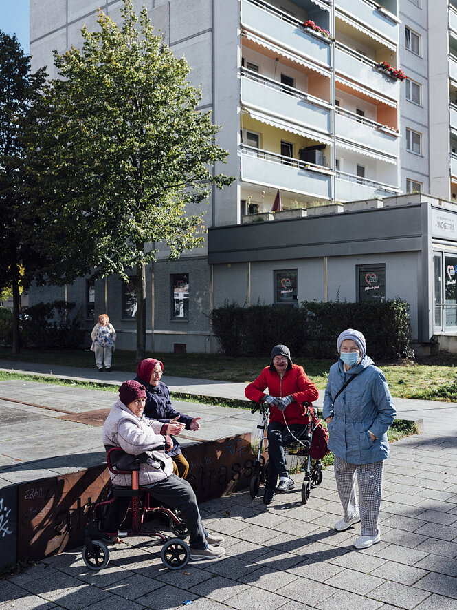 Vier ältere Frauen mit Rollator an einem Treffpunkt im Plattenviertel