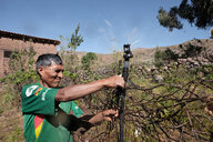 Mann in grünem T-Shirt zeigt ein Bewässerungssystem