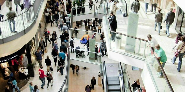 Blick auf Rolltreppen mit vielen Menschen in einem Einkaufszentrum