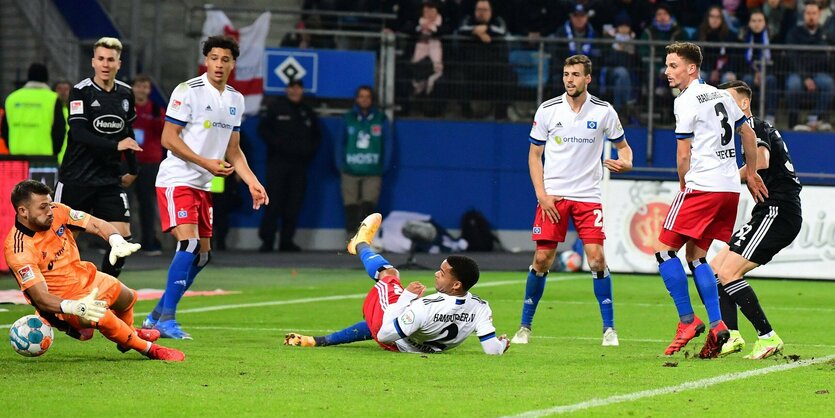 Spielszene, mehrere Fußballspieler sind zu sehen, der Torwart des HSV versucht offenbar den Ball zu halten, aber er ist bereits hinter ihm und wird im Tor landen