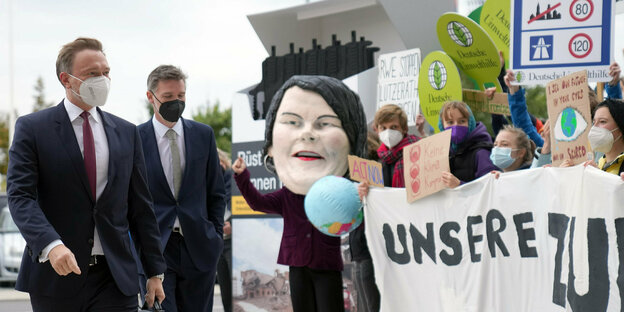 Christian Lindner geht in Berlin vor Klima-Aktivisten vorbei