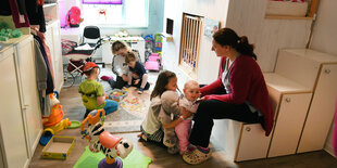 Mutter mit fünf Kindern im Kinderzimmer