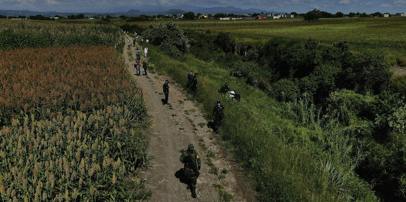 Soldaten und Polizisten auf einem Feldweg