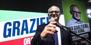 Roberto Gualtieri steht vor seinem Wahlplakat