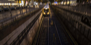 Eine U-Bahn fährt auf den Betrachter zu, Abendstimmung, Verwacklungsunschärfe