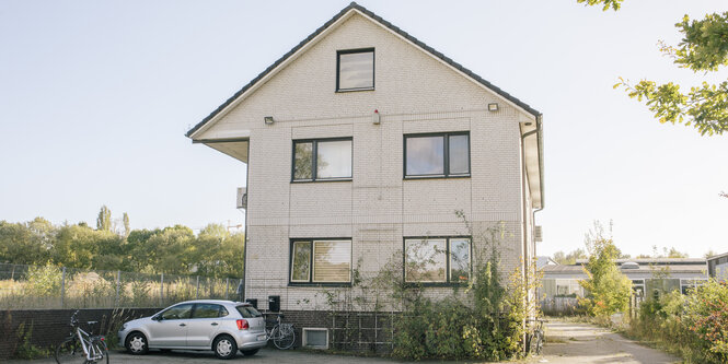 Ein weiß geklinkertes Haus in einer grünen Umgebung