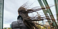 Eine Person mit fliegendem langen Haar im Wind.