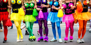 Grell bunte in Regenbogenfarben gekleidet, Röckchen aus Tüll und schwarze Shirts "gegen rechts"