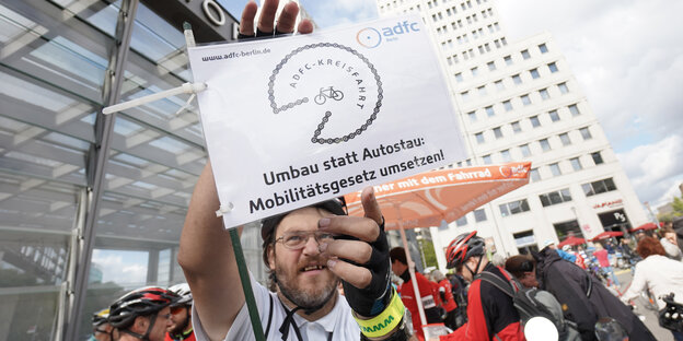 Mann mit Fahrradhelm und Schild "Mobilitätsgesetz umsetzen!"