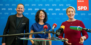Klaus Lederer, Bettina Jarasch und Franziska Giffey stehen bei einer Pressekonferenz zusammen