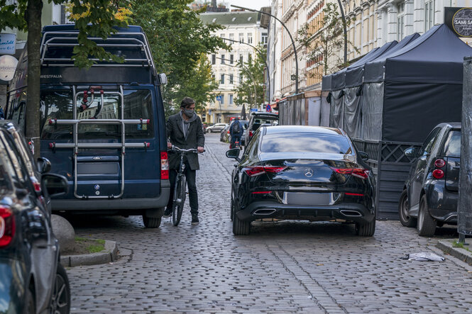 Radfahrer muss absteigen in zugeparkter Straße in Hamburg