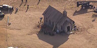 Eine Kulisse auf der Bonanza Creek Ranch aus der Luft, im Hintergrund eine Polizeiabsperrung.