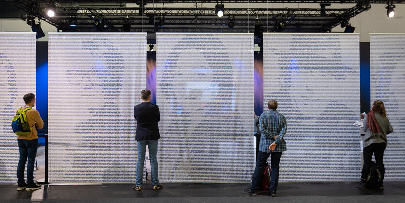 Besucher der Frankfurter Buchmesse blicken in Halle 3.1 af das Blaue Sofa.