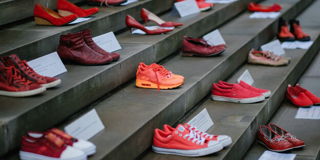 Mehrere rote Schuhpaare stehen auf einer Treppe