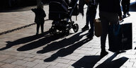Fußgänger werfen ihren Schatten auf das Straßenpflaster