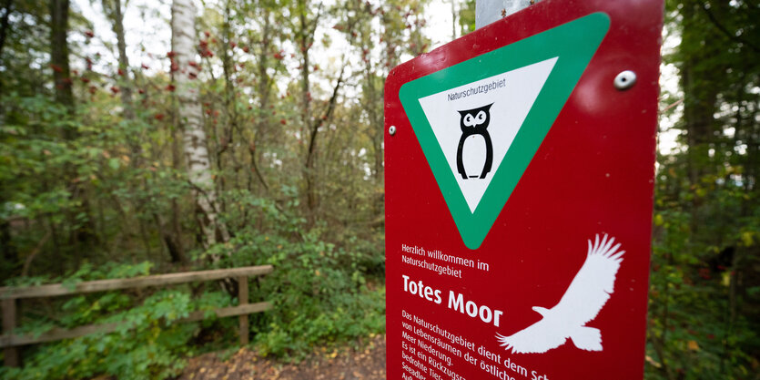 Vor einem Moor steht ein Schild mit der Aufschrift "Naturschutzgebiet"