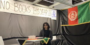 Der leere Stand des afghanischen Verlags Aazam auf der Frankfurter Buchmesse. In der Mitte Yalda Abassi, hinter ihr ein Banner: "No books this year"