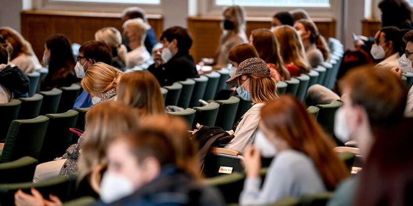 Studierende sitzen mit Masken in einem Hörsaal