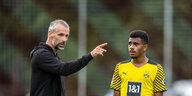 Dortmunds Trainer Marco Rose spricht mit Ansgar Knauff auf einem Fußballfeld.