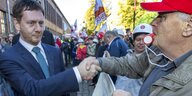 Ministerpräsident Michael Kretschmer schüttelt einem Demonstranten die hand.