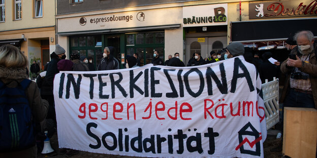 Mehrere Demonstrierende halten einen Banner hoch mit der Aufschrift "Interkiezional gegen jede Räumung. Solidarität""